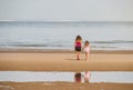 young girl is her mother walking on the beaches of northern France with the English cliffs on the horizon Royalty Free Stock Photo