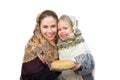 A mother with her daughter are wearing russian kerchiefs holds a plate of pancakes