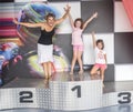 A mother and her daughters on a podium of competition