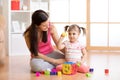 Mother and her kid playing with colorful logical sorter toy