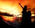 Mother and her kids silhouettes on beach