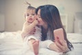 Mother with her little baby having fun in the bed. Mother making Royalty Free Stock Photo