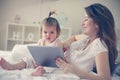 Mother and her little baby at home. Mother with her baby watching something on digital tablet. Royalty Free Stock Photo