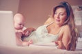 Mother and her little baby at home. Mother working at home. Royalty Free Stock Photo