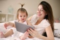 Mother and her little baby at home. Mother with her baby watching something on digital tablet. Royalty Free Stock Photo