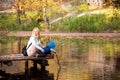 Happy young mother and her son spending time in the autumn park near the pond. Royalty Free Stock Photo