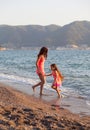 Mother and her little daughter playing and running on the beach Royalty Free Stock Photo