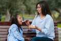 Mother and her little daughter sitting on a bench in the park Royalty Free Stock Photo