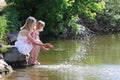 Mother and her little daughter squirting water at the lake