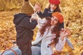 Mother with her little son and daughter is having fun in the autumn park Royalty Free Stock Photo