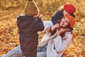 Mother with her little son and daughter is having fun in the autumn park Royalty Free Stock Photo