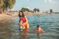 Mother, her little son and daughter making fun in the water Royalty Free Stock Photo