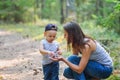 Mother and her little son discovering nature looking on pine-tree cones Royalty Free Stock Photo