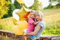 Mother and her little son with gold balloons in summer day. Happy family mom and kid hugging Royalty Free Stock Photo