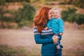 Mother and her little son in a knitwear have a walk in a forest Royalty Free Stock Photo