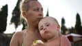 Mother and her little son posing on the beach by the sea