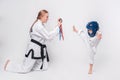 Mother her little son practicing martial arts over white background Royalty Free Stock Photo