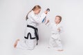 Mother her little son practicing martial arts over white background Royalty Free Stock Photo