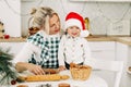 A mother and her little son are preparing Christmas cookies. Happy family in the kitchen. Preparation for the holiday Royalty Free Stock Photo