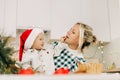 A mother and her little son are preparing Christmas cookies. Happy family in the kitchen. Preparation for the holiday Royalty Free Stock Photo