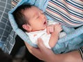 Mother with her sleeping Asian little baby in sling Baby carrier Royalty Free Stock Photo