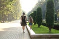 Mother and her small daughter with long hair walking together holding hands in summer park Royalty Free Stock Photo