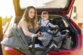 mother with her son behind the car preparing the trip