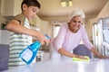 Mother and her son cleaning kitchen surface together