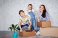 A mother with her son and daughter moves into a new apartment with things in cardboard boxes. The family creates a roof Royalty Free Stock Photo