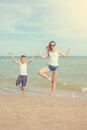 Mother and her son doing yoga on coast of sea on beach. Royalty Free Stock Photo