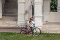 Mother and her son going with bicycles in the park, side view. Family spending active vocations in the summer.