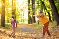 Mother and her son are having fun in the autumn park. A beautiful woman throws up yellow maple leaves while her adorable toddler Royalty Free Stock Photo