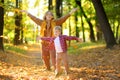 Mother and her son are having fun in the autumn park. A beautiful woman throws up yellow maple leaves while her adorable toddler Royalty Free Stock Photo