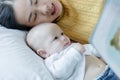 Mother and her son reading book in a bed before sleep. Familly story telling concept