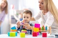 Mother and her baby son building toy pyramid tower Royalty Free Stock Photo