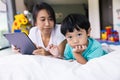 mother and her son using digital tablet in a bed at home. The use of concept of new generation  family  parenthood  authenticity Royalty Free Stock Photo