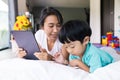 mother and her son using digital tablet in a bed at home. The use of concept of new generation  family  parenthood  authenticity Royalty Free Stock Photo