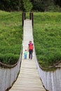 Mother with her toddler son walk on suspension bridge. Adventure