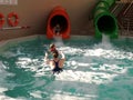 Mother and her two children to the slides in the pool Royalty Free Stock Photo