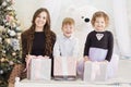 Mother and her two little children with Christmas gift boxes. Family on Christmas eve. Mother and little kids opening Xmas Royalty Free Stock Photo