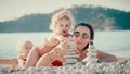 Mother and her two little girls having a good time on the beach. Building a pebble tower, faamily life balance concept Royalty Free Stock Photo