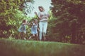 Mother with his daughter in meadow. Little girls caching their m Royalty Free Stock Photo