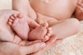 Mother hold feets with gold ring of newborn baby Royalty Free Stock Photo