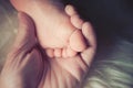 Mother hold small bare feet of a little baby girl or boy. Sleeping newborn child. Royalty Free Stock Photo