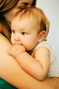 Mother Holding Baby Calming Her Newborn Child Mom Gently Soothing Infant. Five month old baby with blue eyes. Royalty Free Stock Photo