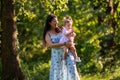 Mother holding baby clapping in park Royalty Free Stock Photo