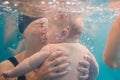 Mother holding baby dive. Diving baby, mother in paddling pool. Young mother, swimming instructor and happy little girl under Royalty Free Stock Photo