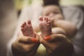 Mother holding baby feet in hands. Focus on feet. Royalty Free Stock Photo
