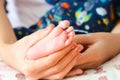 Mother holding baby feet in her palms