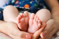 Mother holding baby feet in her palms